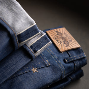 Selvedge jeans with a leather label on a dark background