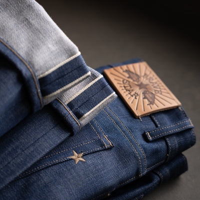 Selvedge jeans with a leather label on a dark background